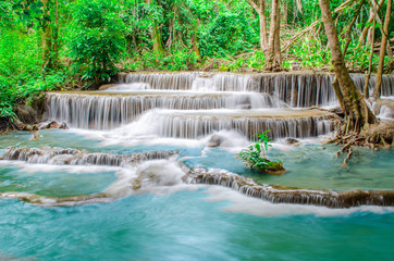 Travel to the beautiful waterfall in tropical rain forest, soft water of the stream in the natural park at Huai Mae Khamin Waterfall in Kanchanaburi, Thailand.