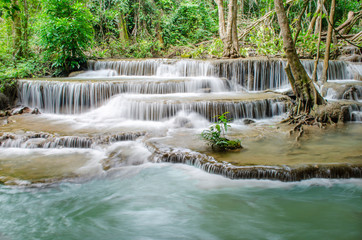 Travel to the beautiful waterfall in tropical rain forest, soft water of the stream in the natural park at Huai Mae Khamin Waterfall in Kanchanaburi, Thailand.