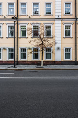 Fototapeta na wymiar Facade of yellow building with white windows in Moscow on the street Ulitsa Bol'shaya Yakimanka, 4-6