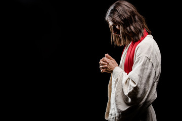 bearded man praying with clenched hands isolated on grey