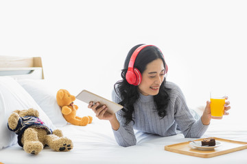 Fototapeta na wymiar Asian woman wearing headphone in bedroom..