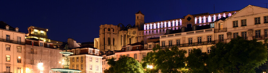 night view of bronze fountains and illuminated buildings at Praca Dom Pedro IV, Rossio square in Lisbon, Portugal