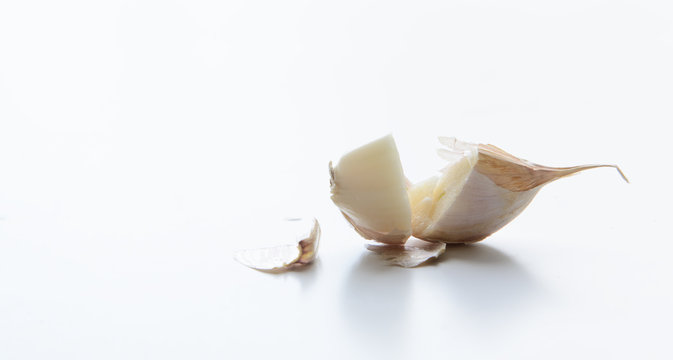 Sliced clove of garlic with husk on a white background. Concept - Natural Medicine Treatment