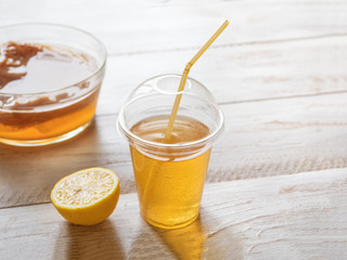 OLKombucha fungus. Organic fermented tea drink with lemon on a white wooden table.