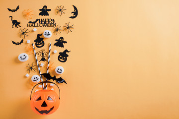 Top view of Halloween crafts, orange pumpkin, ghost, bat and spider on orange background with copy...