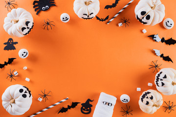 Top view of Halloween crafts, orange pumpkin, ghost, bat and spider on orange background with copy space for text. halloween concept.