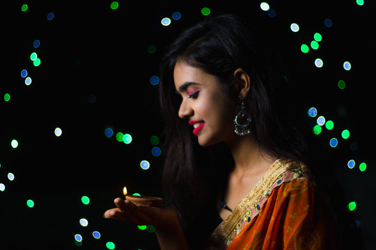 young indian woman holding diwali lamp on bokeh background generative AI  29642826 Stock Photo at Vecteezy