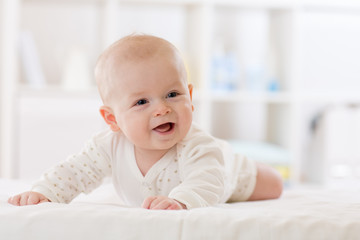 infant baby five months age lying on belly in nursery