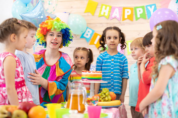 Fototapeta premium kids celebrating birthday party with clown