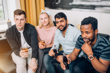 Group of friends watching television at home together