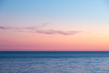Beautiful Summer landscape sunset image of colorful vibrant sky over calm long exposure sea