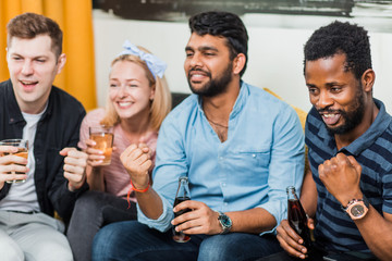 Group of friends watching television at home together