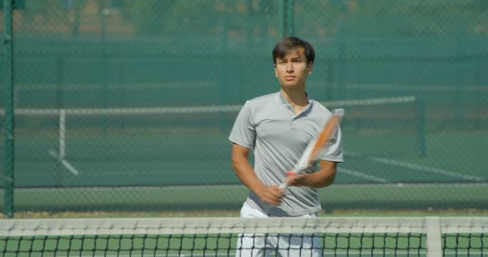 A mixed race tennis player hits a volley and celebrates being number one.