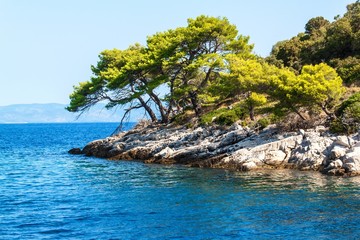 Rocky coast of the Croatian island of Lastovo. Pine trees on seacoast. View from the deck of the yacht. Holiday in Croatia. Sailing on the sea.