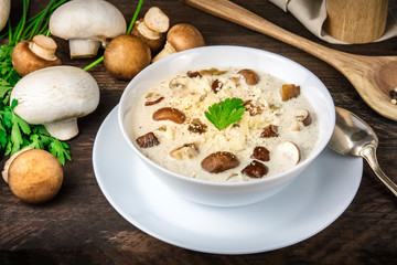 Mushroom soup with ingredients on a dark rustic wooden background