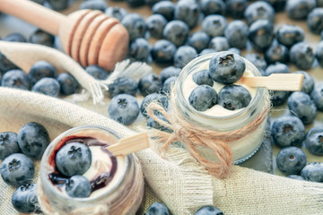 Fototapeta na wymiar jars of yogurt with blueberries, honey and chocolate