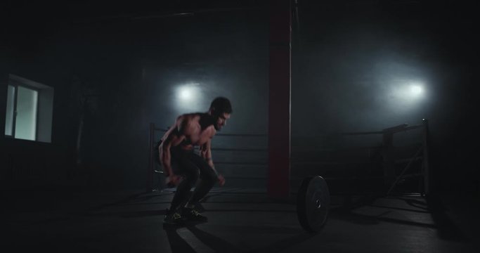 Attractive athletic guy doing hard workout in the cross fitness very strong guy practicing cross fitness exercises