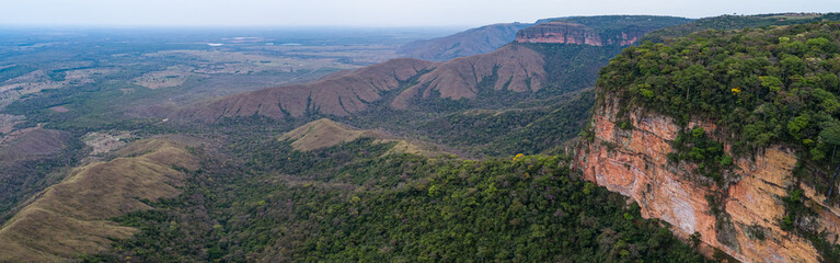 Fototapeta na wymiar Aerial view of table mountains cliffs with foothills covered with rainforest, Chapada dos Guimarães, Mato Grosso, Brazil, South America