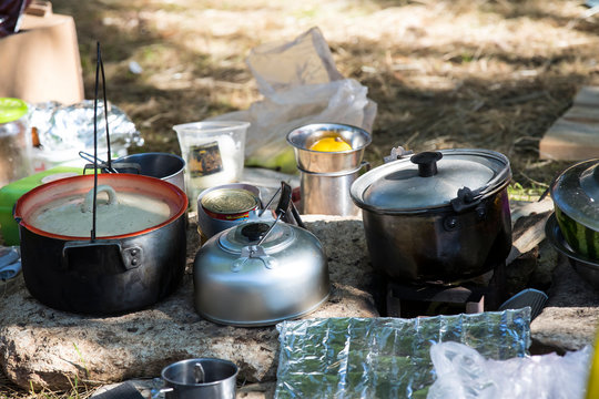 Iron pot cooking food over an open fire.