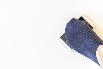 落としたスマートフォンを踏んでいる男性の足