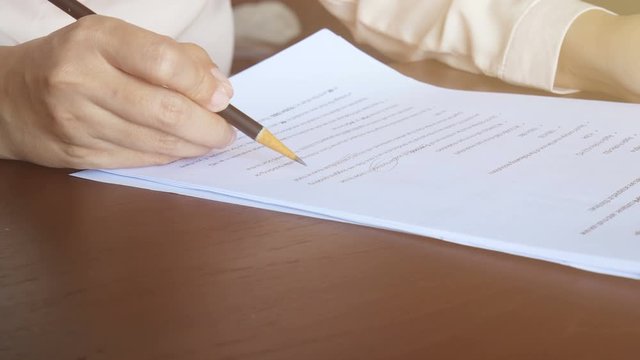 4K. woman reading on paper , flip page and use pencil to marking text on document