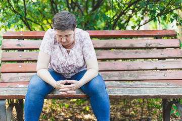Fototapeta premium Senior woman standing alone in the park