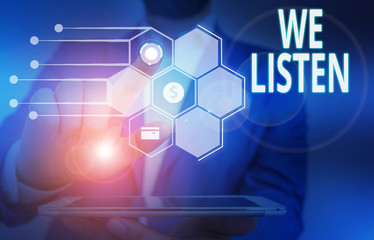 Fototapeta premium Conceptual hand writing showing We Listen. Concept meaning Group of showing that is willing to hear anything you want to say Male wear formal suit presenting presentation smart device