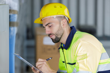 male technician writing on clipboard