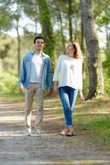 young couple walking in forest