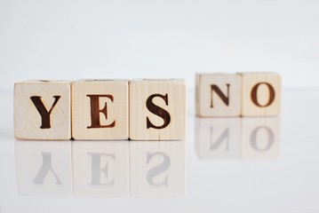 Words YES and NO on wooden blocks.