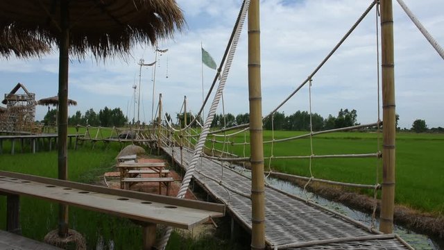 View landscape wooden bridge in rice field for Thai people and foreign travelers travel visit and take photo of coffee shop at countryside in Ayutthaya, Thailand