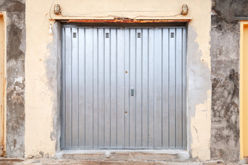 Shiny metal gate in grungy stone wall, texture