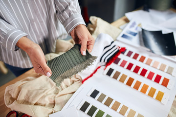 female fashion designer choosing colors for new collection discussing sketches. close up cropped photo.