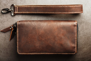 Organizer wallet made of brown Genuine leather, handmade on a dark background