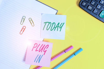 Text sign showing Plug In. Business photo showcasing putting device into electricity to turn it on Power it Connecting Empty blue paper with copy space paper clips and pencils on the yellow table