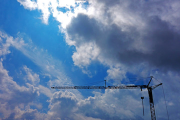 Tower crane in the mountains under storm clouds