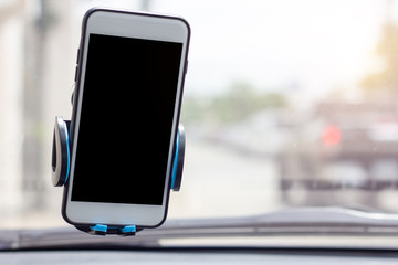 Mobile phone with black blank screen map gps navigation in car windshield holder.
