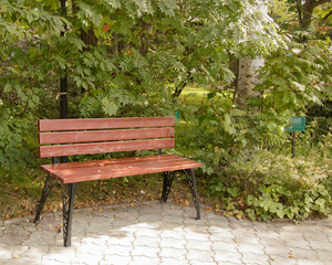 Wooden brown bench with openwork iron legs