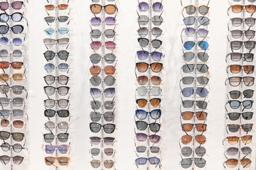 many different sunglasses on display shelves in store, business, helath eyes care. sale, discount