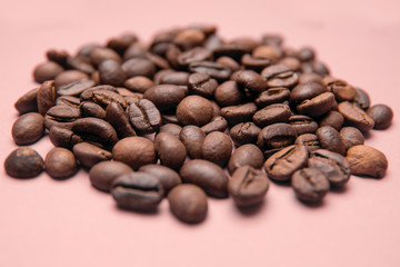 Coffee beans on a pink background.