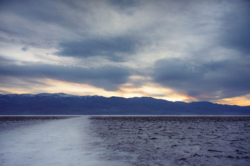 Blue hour image of Bad water basin salty walkway to the blue mountains at Death Valley National Park, USA