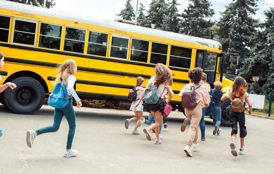 Classmates running to school bus back view late