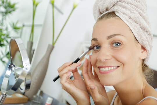 A Happy Woman Applying Eyeshadow