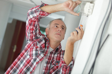 technician mending the emergency exit symbol
