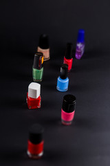 Coloured nail polish bottles on dark background