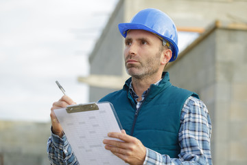 construction manager writing report at construction site