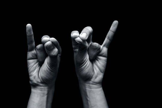Pair of male teenager's hand doing Mahasirs Mudra isolated on a black background which reduces headache, stress and tension.