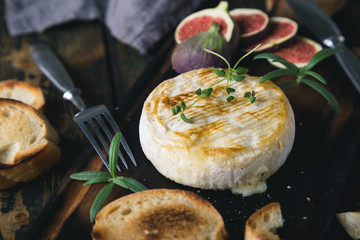 Camembert cheese with crackers, figs and herbs