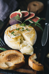 Camembert cheese with crackers, figs and herbs