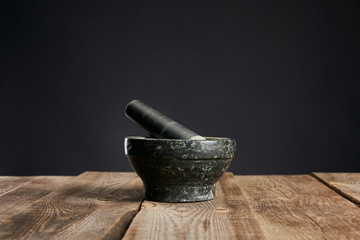 grey stone mortar on wooden table isolated on black